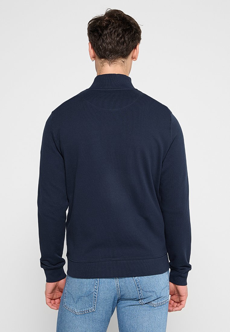 Navyblauer Sweatshirt, aus dickem Strickstoff, mit hohem Kragen und gerippten Bündchen. Schlichtes Design mit einer glatten Textur.