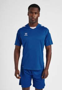 Blå sportsjersey med korte ærmer, V-hals og hvide detaljer. Kombineret med matchende blå shorts lavet af let og åndbart materiale.