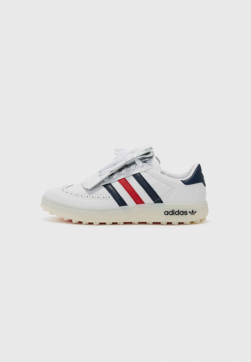 Vita lädersneakers med marinblå och röda ränder, perforerade detaljer på tån och en texturerad gummisula med en synlig varumärkeslogotyp.