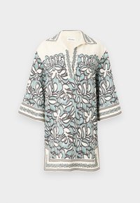 Bluză cu mânecă scurtă în crem, cu un model floral în albastru deschis și marron, având un guler în formă de V și accente decorative de-a lungul marginilor.