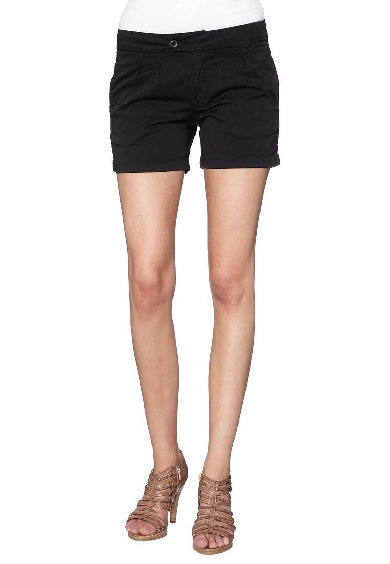 Shorts en coton noir avec une coupe ajustée, dotés de poches avant et d'un ourlet roulé. Associés à des sandales à talons hauts à lanières beiges.