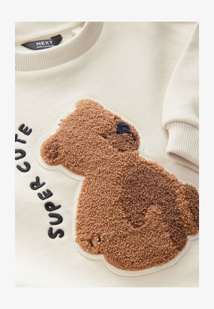 Kremfarvet sweatshirt med applikation af en brun plysbjørn med tekstureret pels og sort broderet tekst, der lyder "SUPER CUTE." Med ribkant ved halsudskæring og ærmer.
