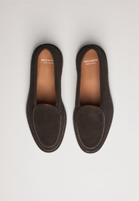 Brune ruskind loafers med rund tå og enkelt design. Afsluttet med kontrasterende syninger og mærkede indersåler. Fremstillet i Spanien.