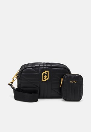 Schwarze, gesteppte Umhängetasche mit goldenem Logo und abnehmbarem kleinen Beutel, ausgestattet mit einem breiten, verstellbaren Schultergurt und Reißverschlüssen.