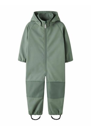 Combinaison imperméable pour tout-petit à capuche verte, fermeture éclair avant, poignets élastiques, renforts aux genoux et sangles aux pieds pour un maintien sécurisé.