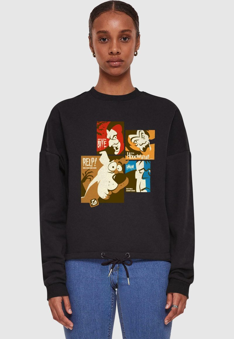 Czarny sweatshirt z graficznym nadrukiem przedstawiającym ilustracje w stylu kreskówkowym w brązowych, żółtych i niebieskich odcieniach, ukazującym różne postacie z dodatkowymi napisami.