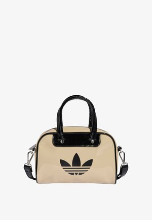 Beige lakleren tas met zwarte accenten, voorzien van dubbele handvatten en een afneembare schouderriem. Voorkant met logo-ontwerp in zwart.