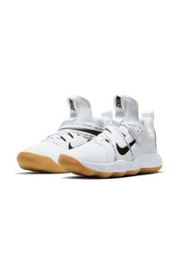 Baskets blanches avec une semelle en caoutchouc, tige en mesh, swoosh noir de Nike et sangle avec le texte "Just Do It".