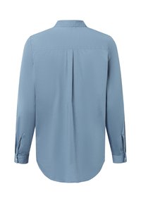 Camicia a maniche lunghe azzurro chiaro con colletto standard, orlo curvo, piega centrale sul retro e dettagli con polsini abbottonati. Tessuto liscio e intrecciato.