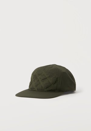 Casquette de baseball en tissu matelassé vert foncé avec motif en losange cousu sur le panneau avant et visière incurvée sur fond neutre.
