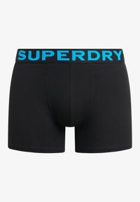 Boxers noirs avec une ceinture élastique bleue ornée du logo "SUPERDRY". Fabriqués en un matériau doux et extensible.