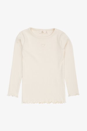 Hellbeige Langarmoberteil mit gerippter Textur, rundem Ausschnitt, kleiner Herzstickerei und Rüschensaum an den Ärmeln und am unteren Saum.