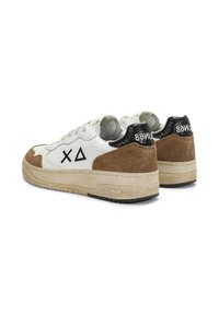Sneaker bianchi e marroni con simboli geometrici neri sui lati, dettaglio del tallone in texture pitone nera e suole beige, viste da dietro e di lato.