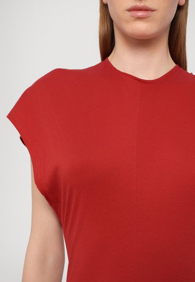 Punainen lyhythihainen paita, jossa on pyöreä pääntie, valmistettu pehmeästä ja kevyestä kankaasta. Ominaisuuksina minimalistinen muotoilu ja hienovarainen rakenne.