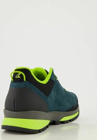 Herren Sportschuhe mit einem Obermaterial aus dunkelblauem Wildleder, schwarzen Akzenten, lebhaften grünen Details und einer robusten schwarzen Sohle mit Profil.