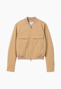 Veste bomber beige avec fermeture éclair devant, deux grandes poches à rabat, col et poignets côtelés, et coupe légèrement raccourcie.