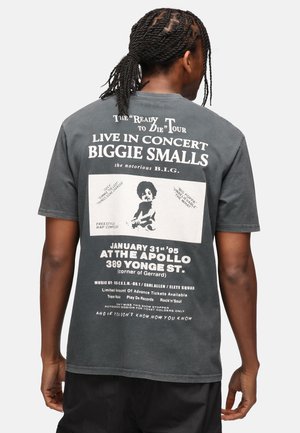 Camiseta de algodón negra con gráficos de concierto de Biggie Smalls en la parte posterior, incluyendo texto, una foto y detalles del evento. Mangas cortas.