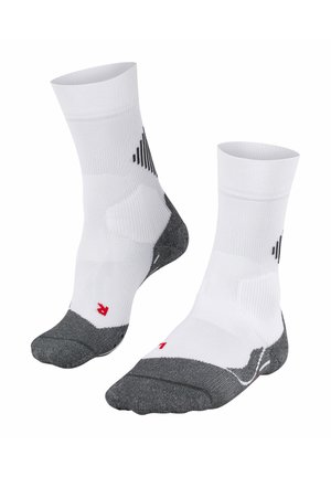 Chaussettes de sport blanches avec un renfort gris au niveau des orteils et du talon, présentant un design texturé sur le dessus et un accent de logo rouge sur la semelle.