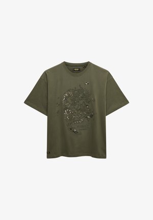 T-shirt à manches courtes vert olive avec un design de dragon noir et de petits détails réfléchissants sur le devant, col rond.