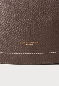 Borsa a tracolla in pelle marrone con texture, con la scritta dorata "GIANNI CHIARINI FIRENZE" e cuciture bianche a contrasto lungo le cuciture.