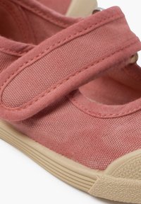 Zapato Mary Jane de lona rosa para niña con una correa de Velcro, punta redonda y suela de goma beige en contraste. Tela texturizada con costuras sutiles.