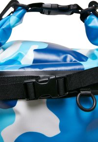 Blå og hvid camouflagemønstret vandtæt taske med en sort rem, plast spænde og metalring. Glat, blank tekstur.