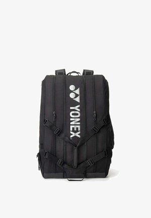 Zwarte Yonex sportrugzak met meerdere verticale ritsen en verstelbare banden op een witte achtergrond.