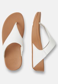 Sandali in pelle bianca con suola in gomma marrone imbottita, caratterizzati da una texture liscia e da un design semplice ma moderno.
