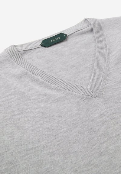 Jasnoszary sweter typu V-neck z miękkiego, gładkiego materiału z prążkowanymi brzegami. Metka z napisem "Zanone" w ciemnozielonym kolorze. Brak widocznych wzorów lub ozdób.