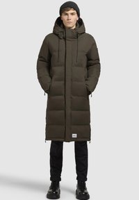  gevoerde parka in donkergroen, met een capuchon, ritszakken, verstelbare trekkoorden en een logopatch aan de onderrand.