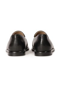 Chaussures habillées en cuir noir avec une finition lisse, un dos arrondi et des talons bas. L'intérieur est doublé d'un matériau marron clair.