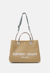 Vävd halm tote-väska med bruna läderhandtag, silverdetaljer, en justerbar ljusblå rem och vit präglad logotext.