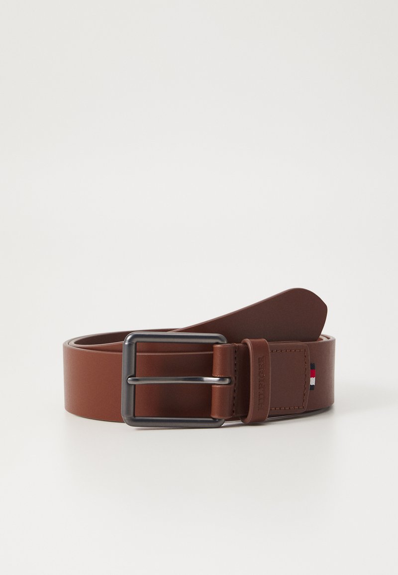 Ceinture en cuir marron avec une boucle en métal argenté. Présente un accent du logo près de la boucle. Texture lisse et design classique.