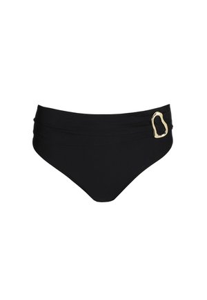 Vrouw die een zwart tweedelig badpak draagt met gouden siergespen, poserend met haar hand op haar heup tegen een effen witte achtergrond.