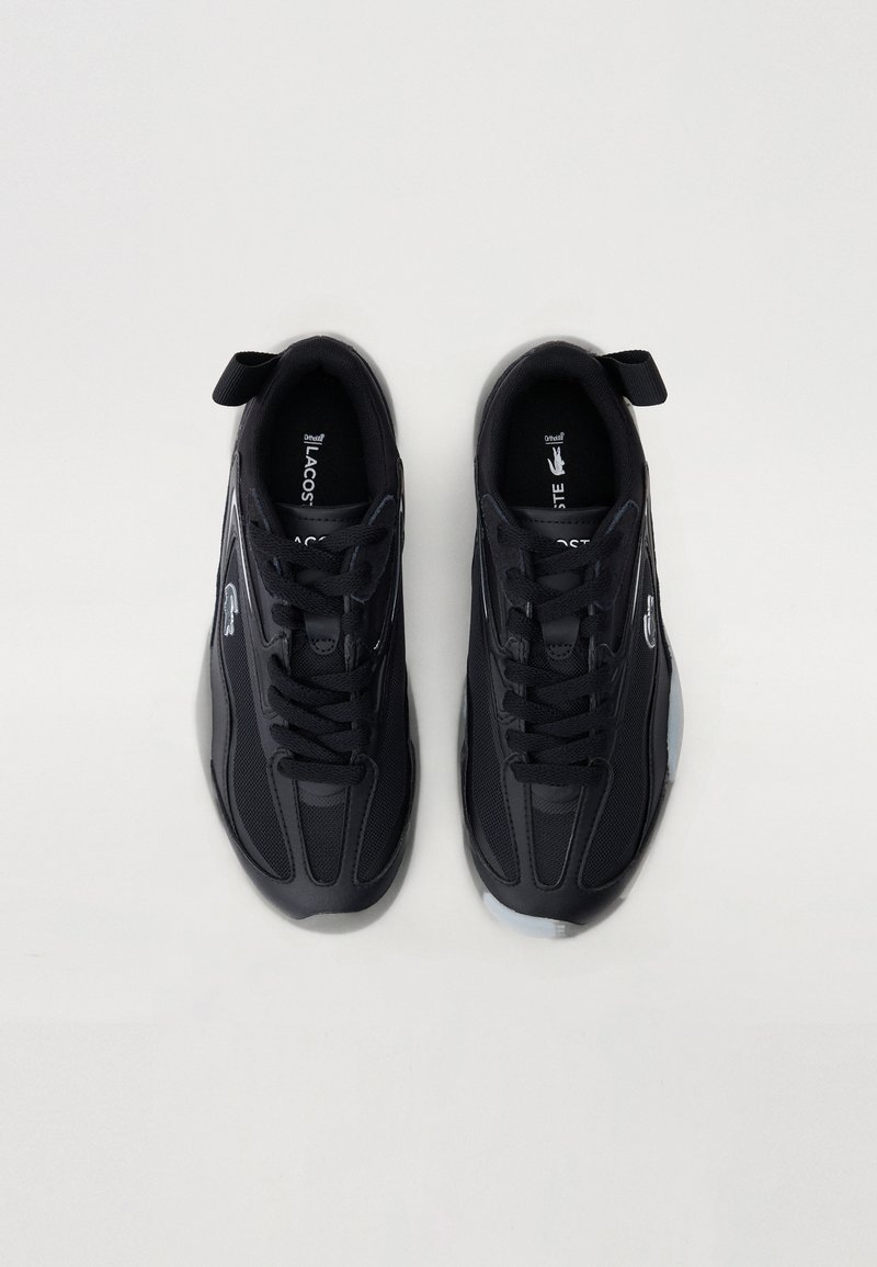 Baskets de sport noires au design épuré, en maille et synthétique, avec un bout arrondi, des lacets et une semelle texturée avec un petit tirant de talon.
