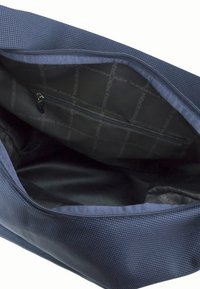 Borsa in tessuto blu navy con un'esterno texturizzato e un interno liscio. Presenta una chiusura con zip e una tasca interna. Motivo con logo del marchio all'interno.