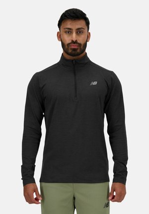 Must beebi pikka varrukaga aktiivne zip-up topp, millel on kõrge krae ja väike peegeldav logo vasakul rinnal. Pehme kangas, millel on sile tekstuur.