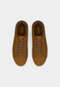 Baskets Aldo marron à lacets avec semelles blanches, vues de dessus sur un fond blanc uni.