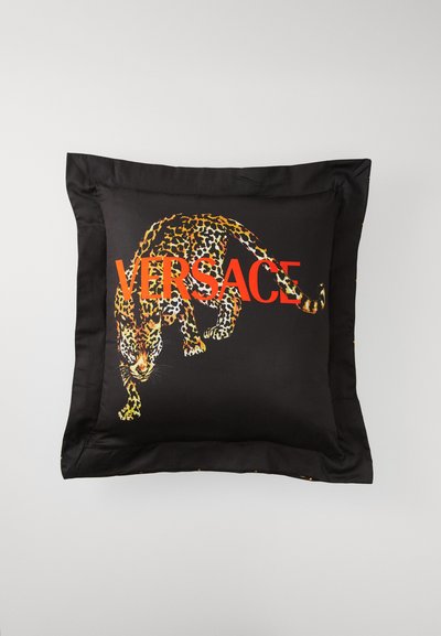 Black silk pillow featuring a leaping leopard graphic and "VERSACE" in bold red lettering. Smooth texture with a satin sheen.