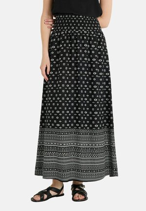 Jupe maxi noire avec une taille smockée, des motifs abstraits blancs sur l'ensemble, et un ourlet à motifs avec des designs géométriques.
