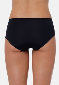 Slip bikini neri con una texture liscia, design a vita bassa e copertura minima. I bordi sono puliti, senza decorazioni o motivi.