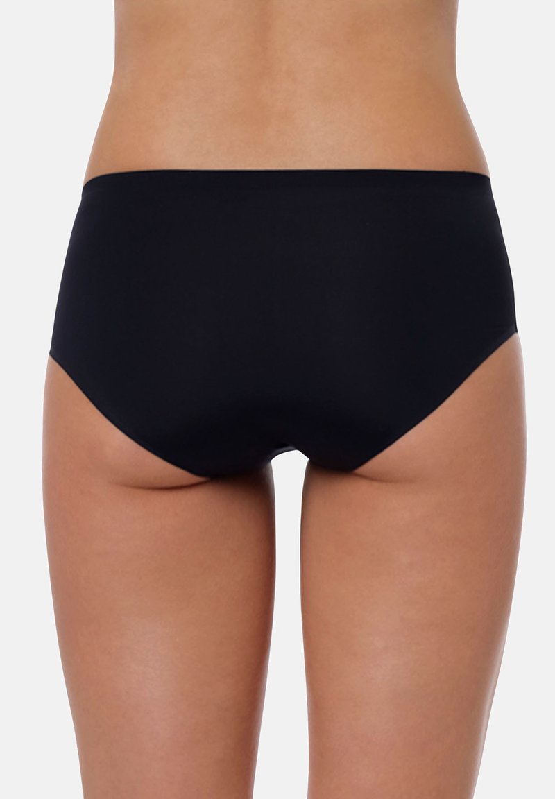 Slip bikini neri con una texture liscia, design a vita bassa e copertura minima. I bordi sono puliti, senza decorazioni o motivi.