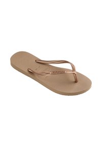 Μπεζ σαγιονάρες Havaianas με υφή στη σόλα και μεταλλικό ροζ χρυσό λουράκι, με ανάγλυφο όνομα εμπορικού σήματος στο λουράκι.