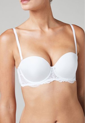 Biały stanik z wypełnieniem, zdobiony koronką wzdłuż taśmy. Posiada regulowane ramiączka i gładki, bezszwowy krój miseczek.