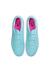 Világoskék focicipők texturált felsőrésszel, fekete Nike logóval, rózsaszín talpbetéttel és szürke fűzőkkel. Összességében egy karcsú sportos dizájn.