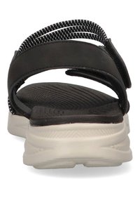 Sandalo nero con cinturini regolabili, soletta testurizzata e suola bianca imbottita; presenta una vista posteriore che mostra il design dei cinturini.