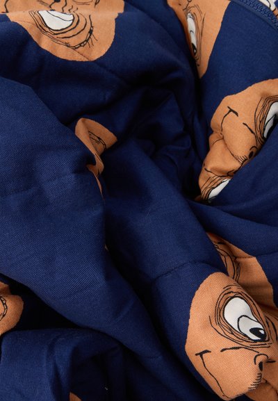 Tamsiai mėlyna medžiaga su animacinių veidų raštu rudos ir baltos spalvos. Medžiaga atrodo minkšta ir susiglamžžiusi, atskleidžianti tekstūruotą dizainą.