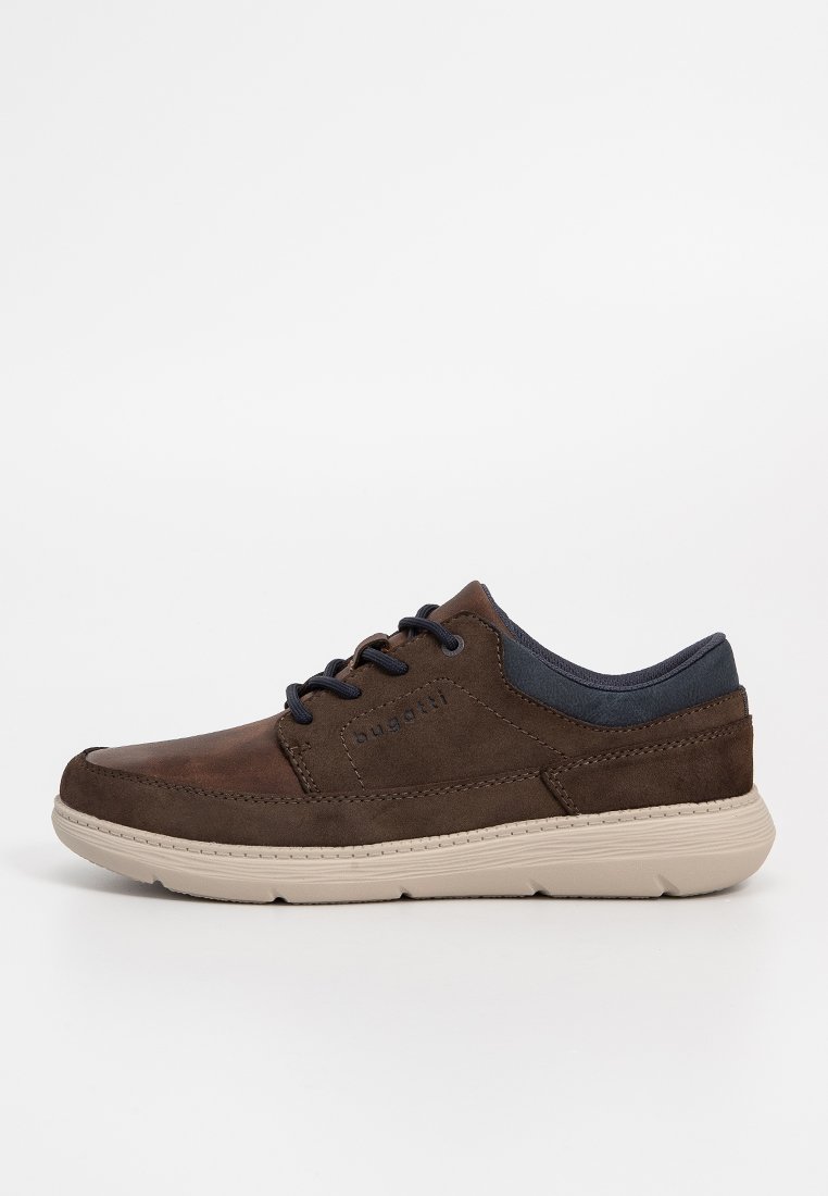 Zapatos de ante marrón con un collar textil azul marino, entresuela blanca y cordones negros. Punta redondeada y detalles texturizados en la parte superior.
