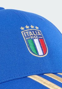 Plava sportska kapa s izvezenim grbom Italije koji sadrži četiri zlatne zvijezde i zelene, bijele, crvene pruge iznad zlatnog rubnog detalja.