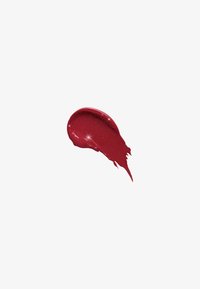 Échantillon de rouge à lèvres pailleté rouge, texture lisse avec une finition brillante. Forme éclaboussure irrégulière, couleur riche avec des particules réfléchissantes.